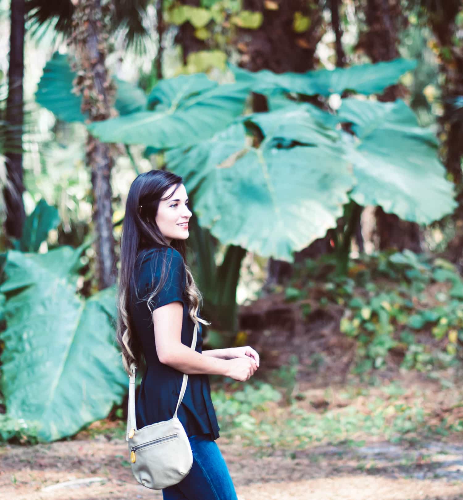 Woman wearing Willoughby Crossbody Bag in a forest setting