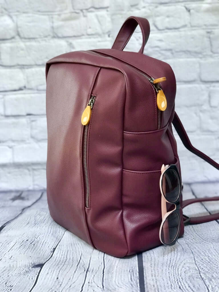 Lenox vegan leather backpack in sleek, minimalist design with comfortable straps and lots of pockets, including space for water bottle and sunglasses.