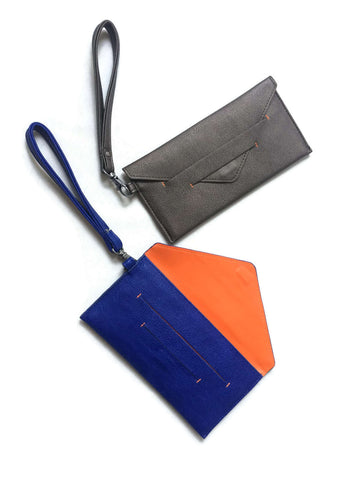 Delancey Wristlet Wallet in gray and blue vegan leather, with orange interior, detachable wrist straps and hidden magnet closure.