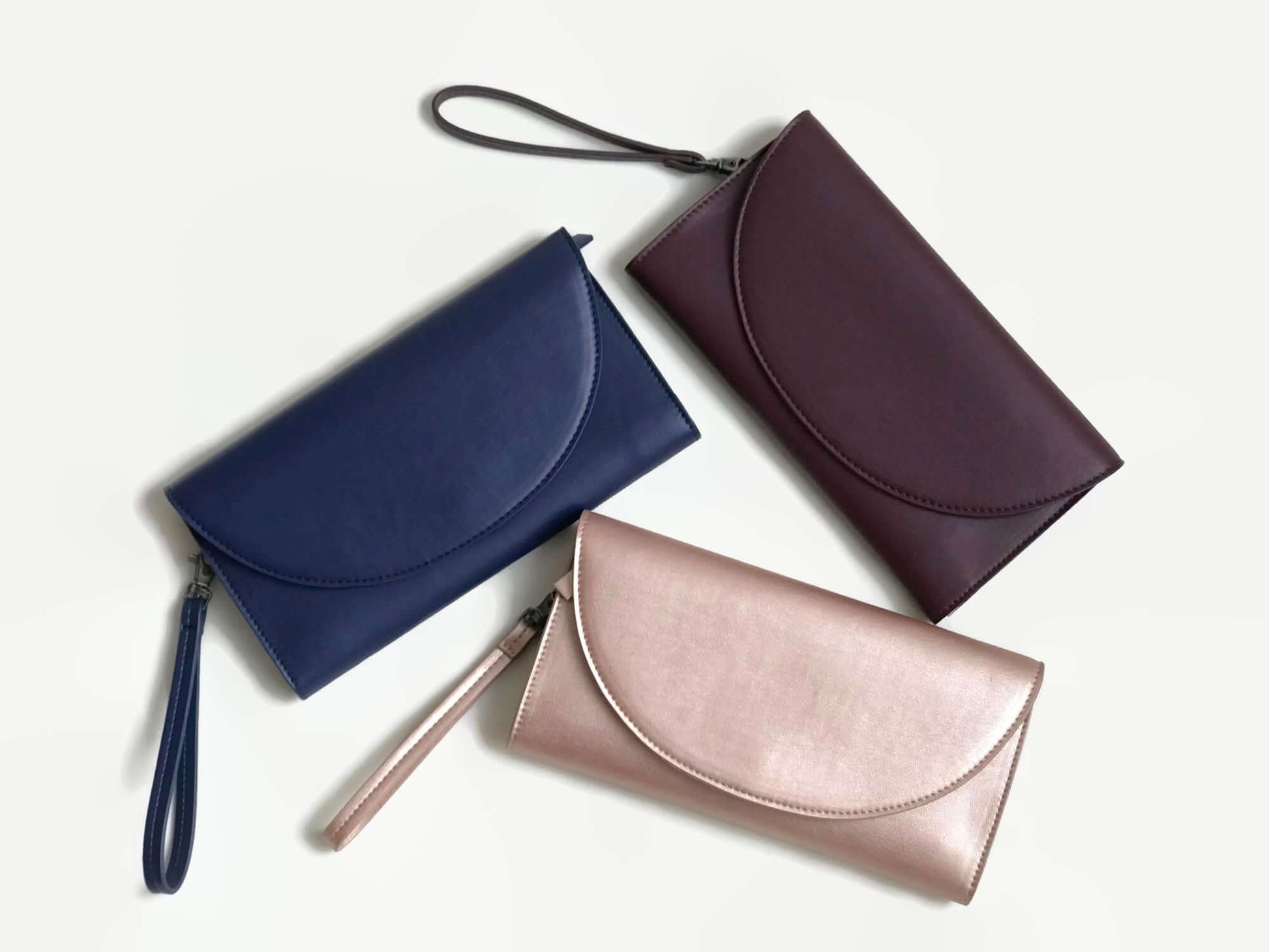 Clark Phone Wallet in vegan leather with wrist strap in three chic colours: navy blue, burgundy, and blush pink by Canopy Verde.