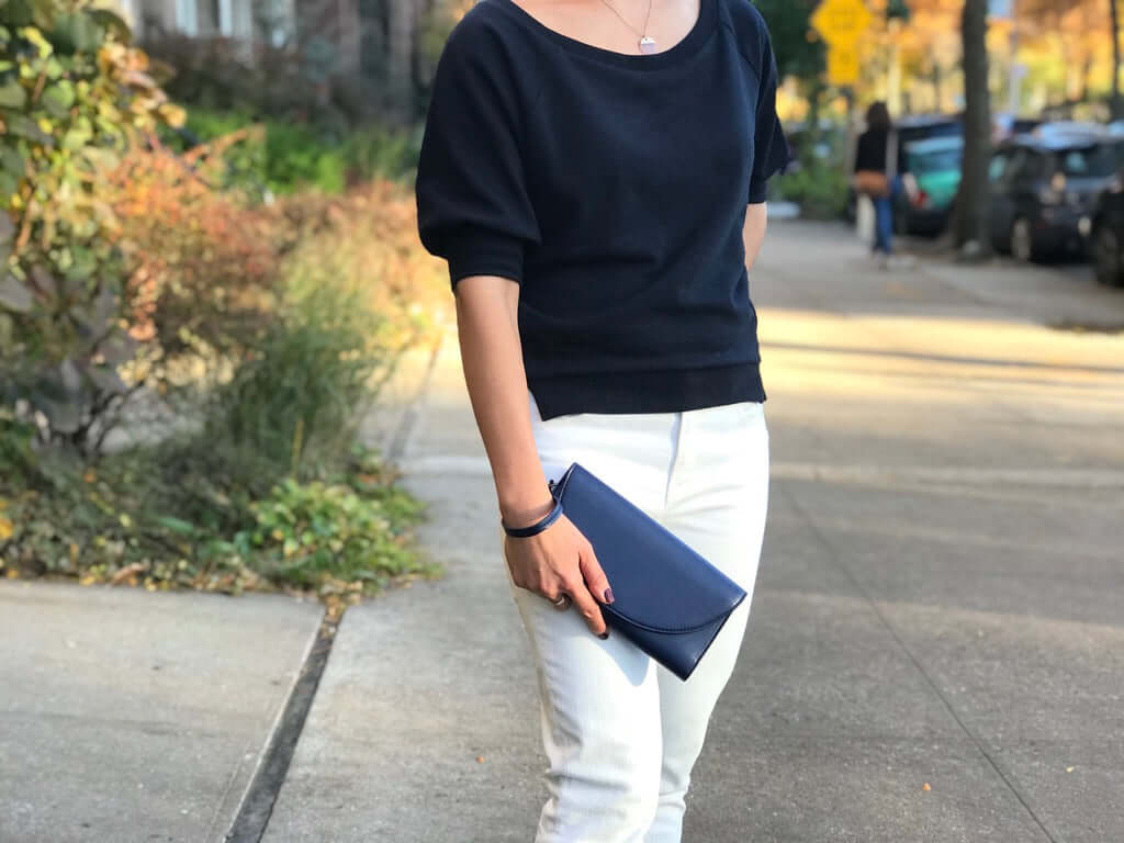 Woman holding Clark Phone Wallet from Canopy Verde in blue on a city sidewalk