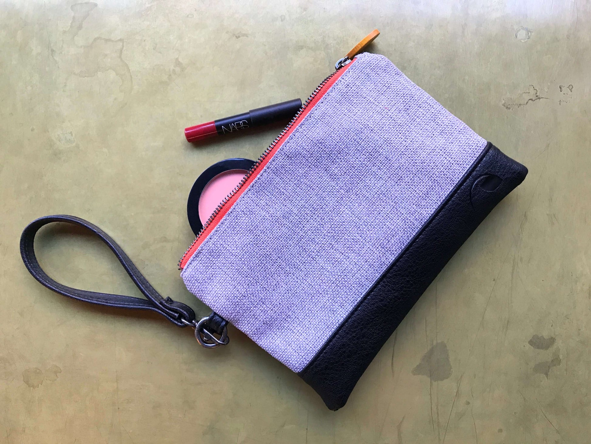 Gowanus Wristlet Clutch in high-quality polyester with black vegan leather accents, featuring wrist strap and red zipper pull.